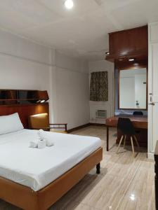 Habitación de hotel con cama, escritorio y escritorio. en 2 Hotel Saleh en Ángeles