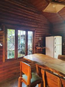 cocina con mesa de madera grande y nevera en Mystic House en Mar del Plata