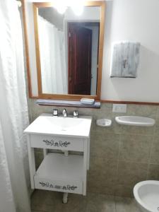 un baño con lavabo y espejo en Cabañas Alegra 1, en San Martín de los Andes 17 fotos más