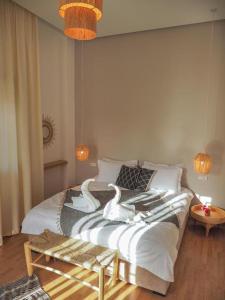 Villa Emraulde في مراكش: غرفة نوم عليها سرير وبجعتين