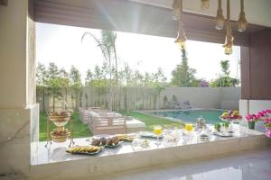 Villa Emraulde في مراكش: طاولة عليها طعام في غرفة مع مسبح