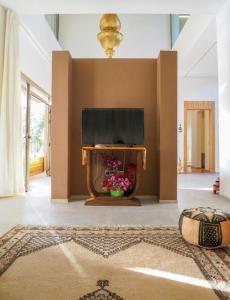 a living room with a fireplace with flowers in it at Villa Emraulde in Marrakech