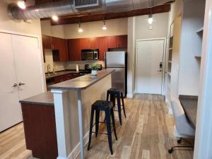 a large kitchen with a counter and stools in it at Fort Worth 2 bedroom Loft Downtown in Fort Worth