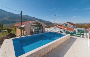 a villa with a swimming pool and a house at Awesome Home In Dugopolje With Outdoor Swimming Pool in Dugopolje