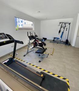 un gimnasio con 2 bicicletas estáticas y una cinta de correr en Departamento full equipamiento, en San Pedro de la Paz