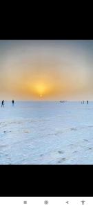 een groep mensen die bij zonsondergang op het strand lopen bij Rann of kutch home stay in Dhordo