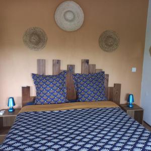 a bedroom with a bed with a blue and white comforter at VILLA LAURAYM in Baie-Mahault