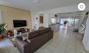 a living room with a couch and a tv at VILLA LAURAYM in Baie-Mahault