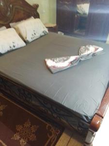 a bed with a wooden frame with a blue mattress at Immeuble chakir in Meknès