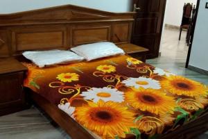 - un lit avec un couvre-lit et des tournesols dans l'établissement Holiday homes in kidangoor kottayam kerala, à Kottayam