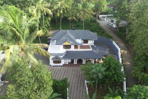 - une vue sur une maison blanche avec des palmiers dans l'établissement Holiday homes in kidangoor kottayam kerala, à Kottayam