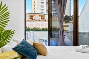 um quarto com uma cama e uma grande janela em Arthur's Hotel Bondi Junction em Sydney