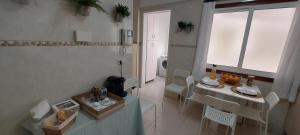 a small kitchen with a table and chairs and a window at Casa das Camelias in Vigo