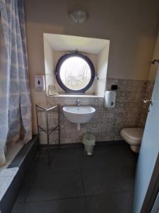 La salle de bains est pourvue d'un lavabo, de toilettes et d'une fenêtre. dans l'établissement Ostello Costa Alta, à Monza