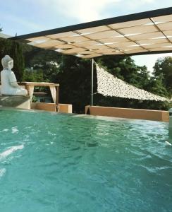 a pool of water with a woman sitting under an umbrella at Rincón de Paz Apart & Loft Suite Boutique - Adults Only in Villa Carlos Paz