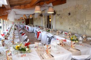 Cette grande chambre comprend des tables blanches avec des fleurs. dans l'établissement Manade des Baumelles, à Saintes-Maries-de-la-Mer