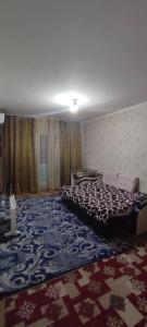 une chambre avec un lit et un tapis à motifs dans l'établissement Bishkek 72, à Bishkek