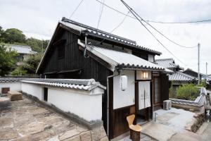 uma pequena casa com um edifício a preto e branco em Villa Kasashima en. 