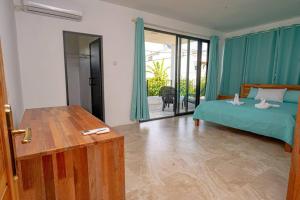 a bedroom with a bed and a door to a patio at Lotus Lane Apartments in Grand Baie