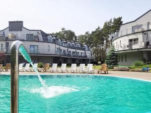 a swimming pool with a water fountain in front of a building at Duplex apartment, 3 bedrooms, pool, Pobierowo in Pobierowo