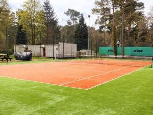 a tennis court with a net on top of it at Duplex apartment, 3 bedrooms, pool, Pobierowo in Pobierowo