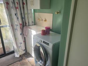 uma lavandaria com uma máquina de lavar roupa e uma máquina de lavar roupa em Single room share bathroom and kitchen em Perth