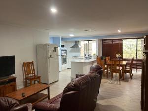 uma cozinha e sala de estar com um sofá e uma mesa em Single room share bathroom and kitchen em Perth