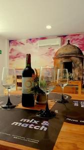 una mesa con tres copas de vino y una botella de vino en Edif HA, en Cartagena de Indias