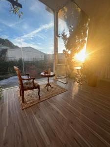 un porche con una silla, una mesa y el sol en VINTAGE HOUSE (Full house) en Xuan An