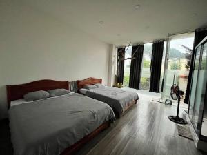 a bedroom with two beds and a large window at VINTAGE HOUSE (Full house) in Xuan An