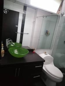 La salle de bains est pourvue d'un lavabo vert et de toilettes. dans l'établissement Cornelio's House, à Bogotá