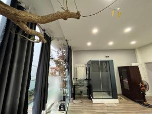 a living room with a tree limb hanging from the ceiling at VINTAGE HOUSE (Full house) in Xuan An