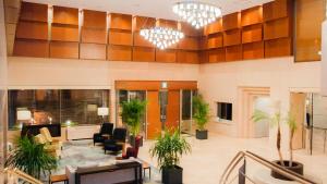a lobby with potted plants and chandeliers at Mitsui Garden Hotel Kumamoto in Kumamoto