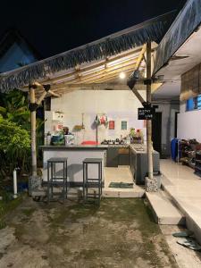 a kitchen with two bar stools and a counter at Kawah Ijen & sukamade Trip By Robiu in Banyuwangi