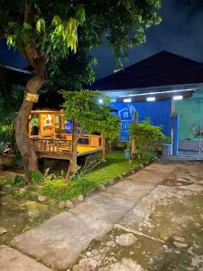 a house with a bench under a tree at night at Kawah Ijen & sukamade Trip By Robiu in Banyuwangi