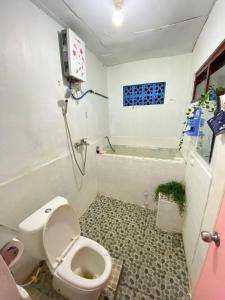 a bathroom with a toilet and a bath tub at Kawah Ijen & sukamade Trip By Robiu in Banyuwangi