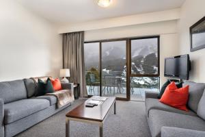 a living room with a couch and a table at Lantern 1 Bedroom Balcony with breathtaking view in Thredbo