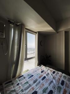 - une chambre avec un lit et une grande fenêtre dans l'établissement Condo Beside Ayala Mall - Centrio Tower, à Cagayán de Oro