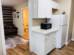 a kitchen with white cabinets and a white refrigerator at Scout in Salem