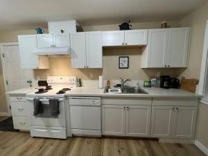 a kitchen with white cabinets and a sink at Scout in Salem