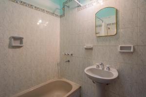 een badkamer met een wastafel, een bad en een spiegel bij San Lorenzo ByB in San Lorenzo