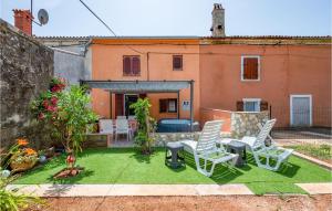a backyard with lawn chairs and a house at Beautiful Home In Pula With Wifi in Pula