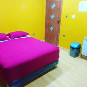 - une chambre avec un grand lit et une couverture rose dans l'établissement Hostal Sin fronteras, à Uyuni