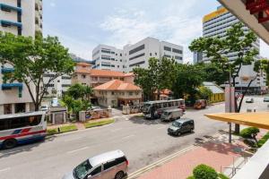 eine Stadt mit Bussen und Autos, die auf einer Straße geparkt sind in der Unterkunft Spacious Studio at citycentre in Singapur