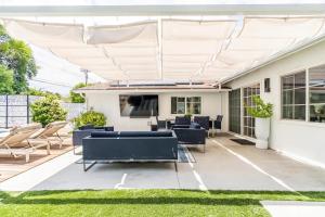 a patio with a white pergola at New luxury entertaining house with Pool Spa Sauna Tesla charger Pets in Los Angeles