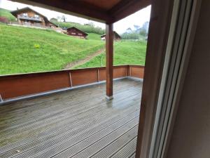a balcony with a view of a green field at Sanner Valley Home in Boltigen