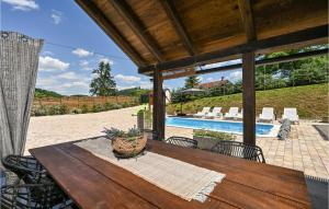 Veliko TrgovišćeにあるPet Friendly Home In Veliko Trgovisce With House A Panoramic Viewの木製テーブルと椅子、プール付きのパティオ