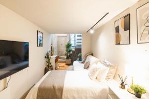 a bedroom with a white bed and a tv at RiriLeo Koenji in Tokyo