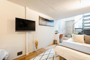 a bedroom with a bed and a flat screen tv on the wall at RiriLeo Koenji in Tokyo