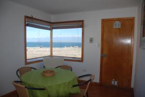 a dining room with a table and a view of the beach at Cabanas Las Hualas in Punta de Choros